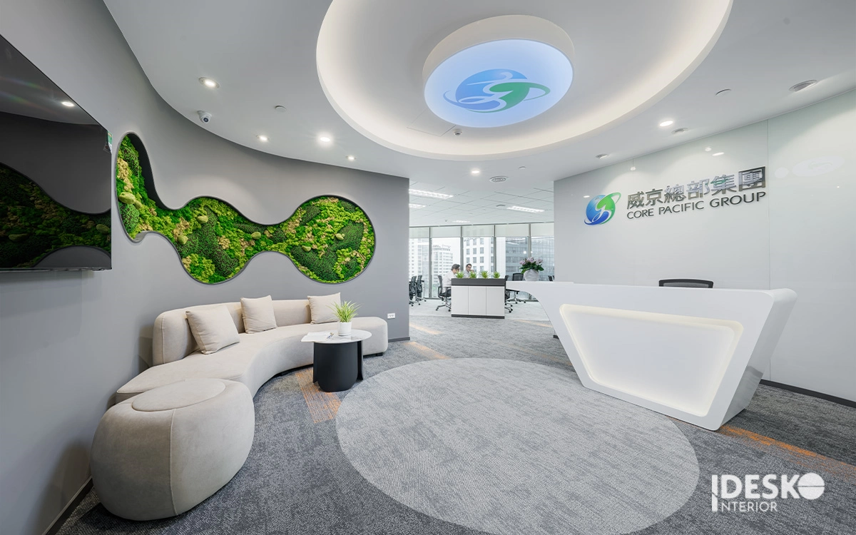 Khu lễ tân hiện đại với quầy tiếp đón bo góc, sofa cong mềm mại và mảng xanh tạo điểm nhấn ấn tượng