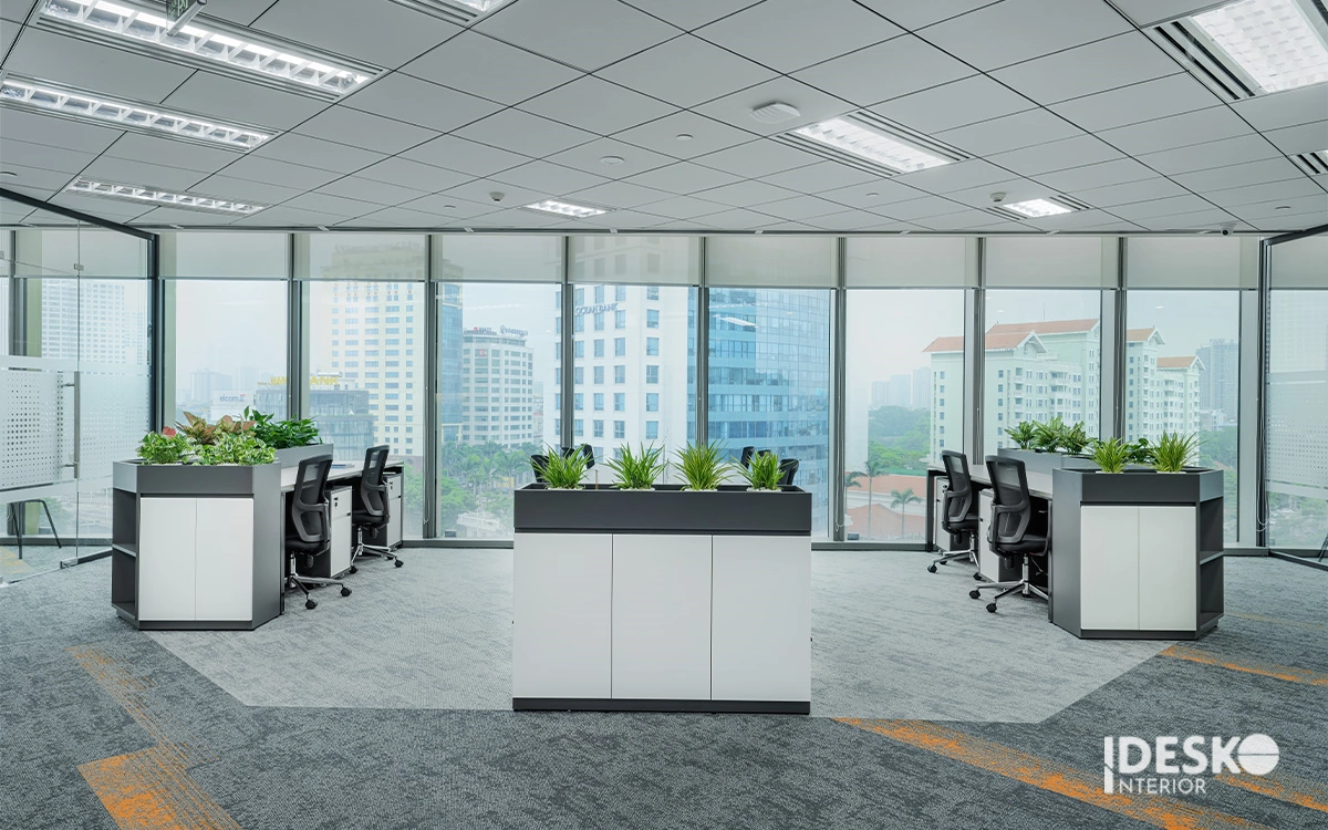 Không gian làm việc hiện đại với vách cây xanh phân khu, cửa kính lớn và tầm nhìn thoáng rộng ra bên ngoài