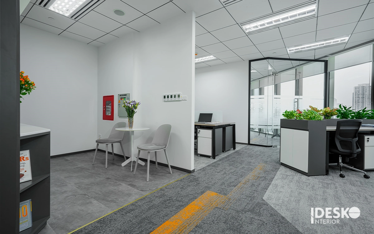 Góc trao đổi nhỏ gọn với bàn trà tiện ích, lối đi rõ ràng và không gian làm việc bố trí ngăn nắp