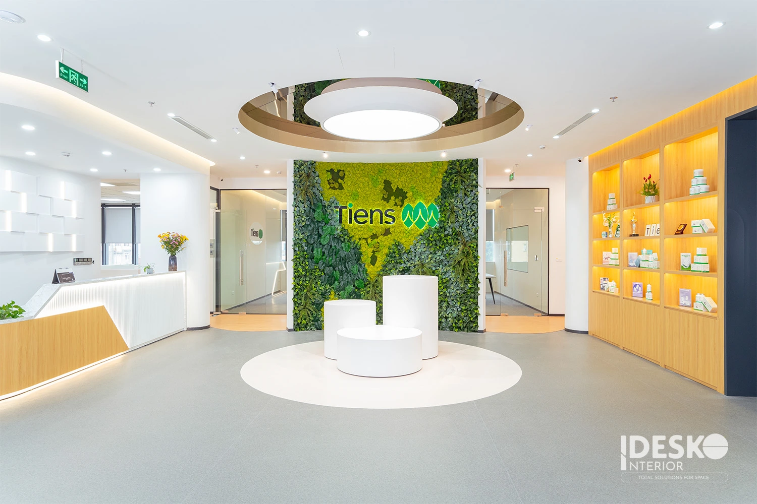 Khu lễ tân hiện đại với mảng tường xanh nổi bật, quầy tiếp đón tinh gọn và không gian trưng bày sáng thoáng