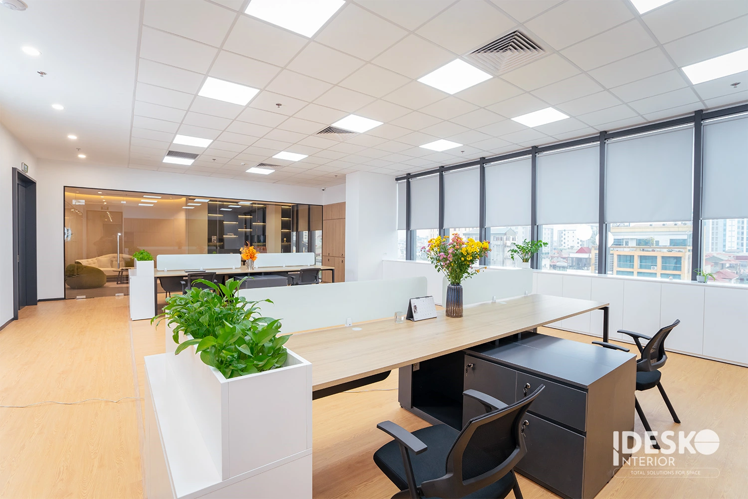 Không gian làm việc sáng thoáng với bàn dài liền mạch, cửa sổ lớn và cách bố trí gọn gàng, hiện đại