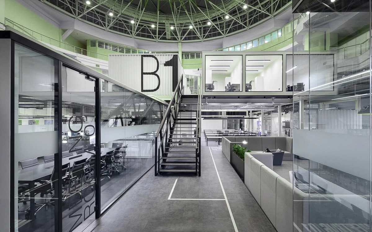 Không gian văn phòng nhà máy với thiết kế mở, kết hợp kết cấu công nghiệp và các module làm việc linh hoạt