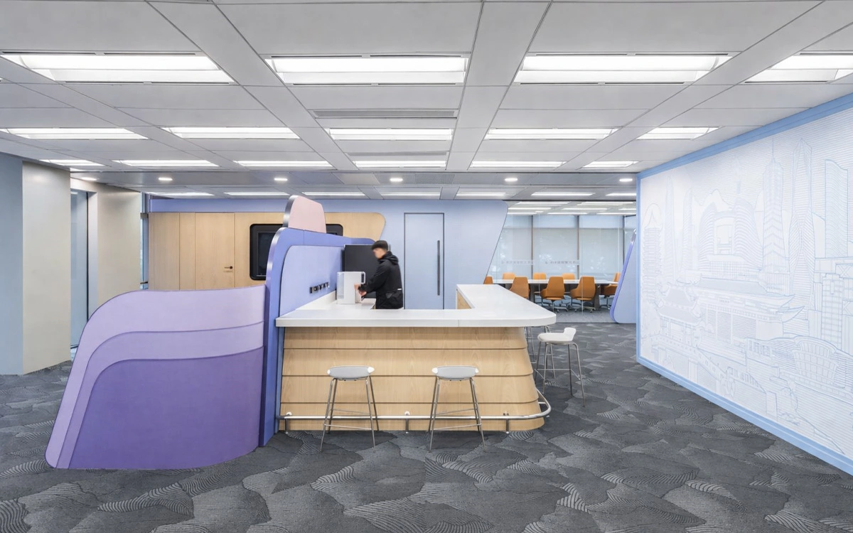 Khu pantry trong văn phòng startup với quầy bar nhỏ, đường nét bo cong và bảng màu trẻ trung