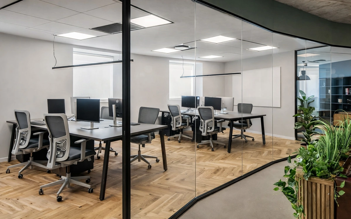Khu làm việc trong văn phòng startup với vách kính trong suốt, bàn ghế đồng bộ và cảm giác gọn gàng, chuyên nghiệp