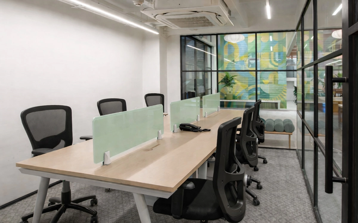 Khu làm việc nhỏ trong văn phòng startup với bàn dài, vách kính và bố cục gọn gàng, linh hoạt