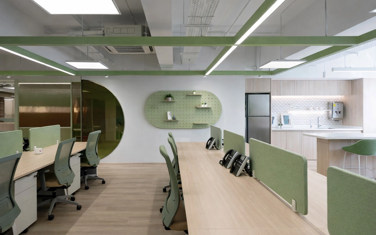 Thiết kế văn phòng startup với bàn làm việc liền dãy, khu pantry mở và tông xanh tạo cảm giác tươi mới
