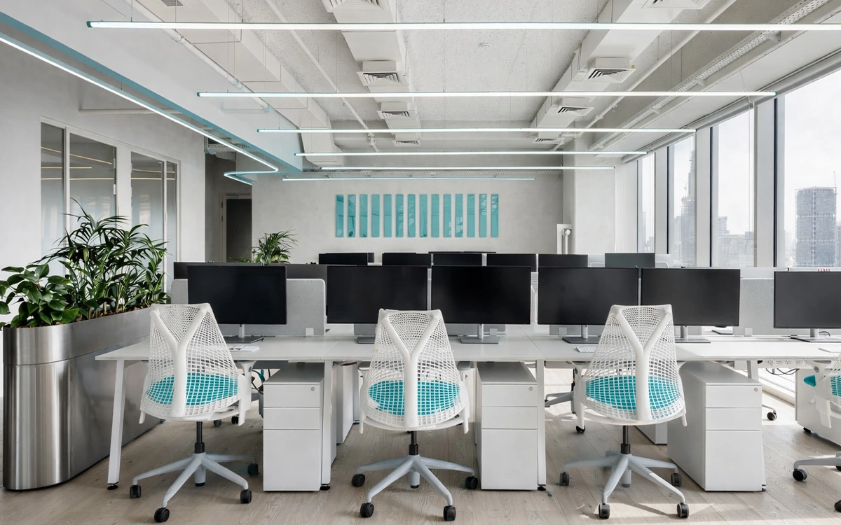 Không gian làm việc trong văn phòng startup với hệ đèn trần nổi bật, ghế lưới đồng bộ và bố cục gọn thoáng