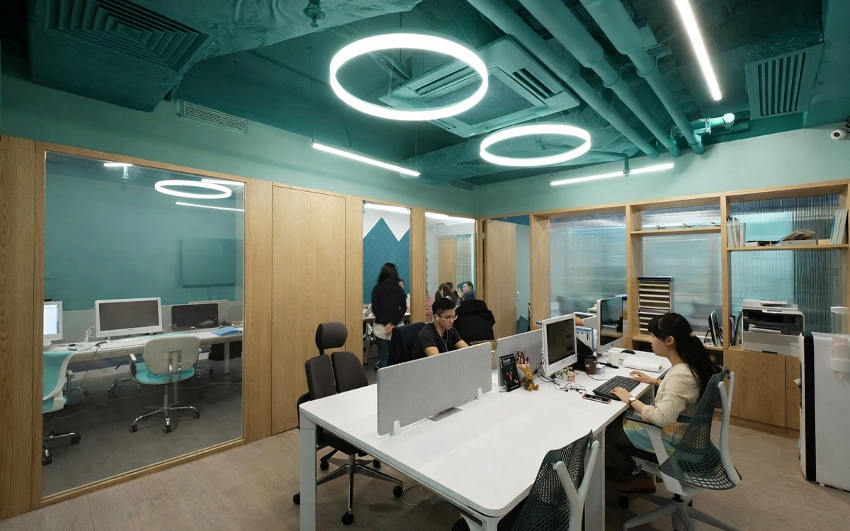 Thiết kế văn phòng startup với khu làm việc nhỏ gọn, vách kính ngăn phòng và tông màu xanh tạo cảm giác trẻ trung